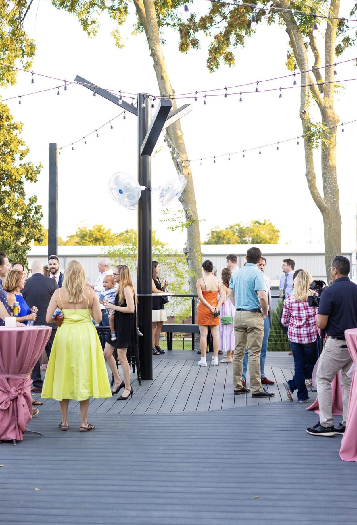 Guests mingling on the deck at golden hour